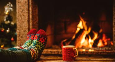 winters plaatje voor de kachel met kerstsokken en kopje warme drank