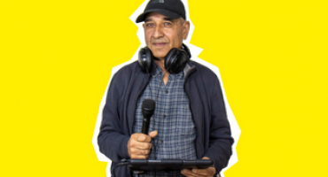Een man met microfoon en tablet in zijn hand 