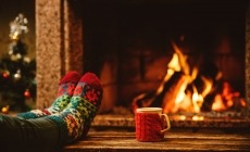 winters plaatje voor de kachel met kerstsokken en kopje warme drank
